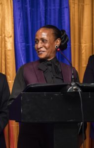Close-up of Lana Reid speaking at the podium during the 2025 Humanitarian Award ceremony hosted by the Eta Nu Nu Chapter of Omega Psi Phi Fraternity.