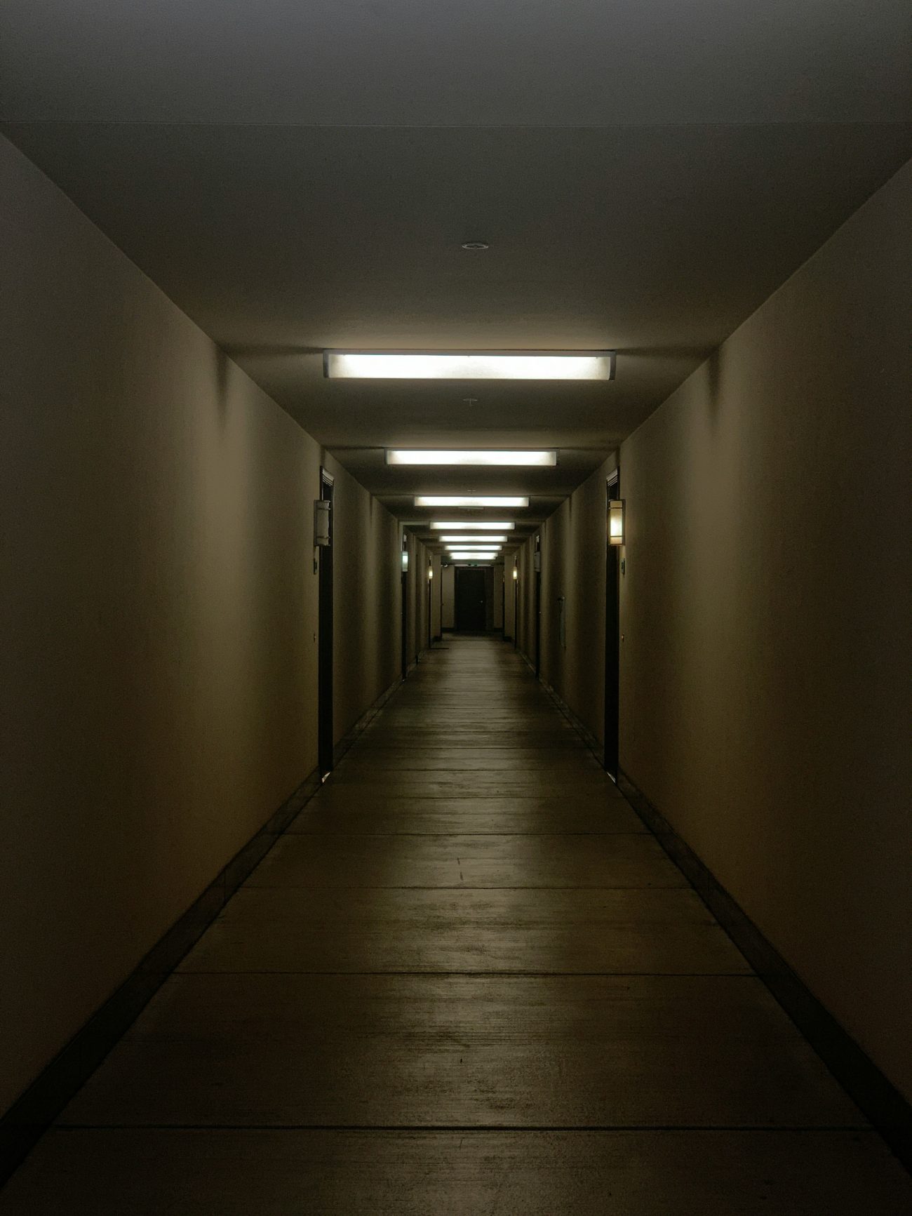 A dimly lit hallway symbolizing gradual influence, moral drift, and the path toward betrayal